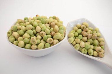 Taze yeşil gözlü bezelye fasulyesi beyaz arka planda beyaz bir kasede lili chori.