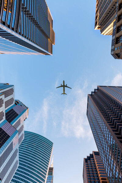 Airplane flying over modern city