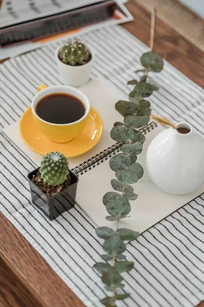 cup of hot coffee with plant on white table. home office concept.