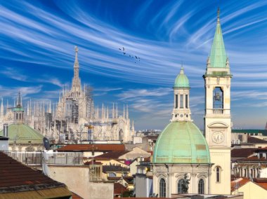 Milano silueti, Duomo di Milanos Gotik kuleleri ile mavi gökyüzü, yeşil bakır çatıları olan tarihi binalar ve uçan kuşlar, şehrin kültürel mirasını yansıtıyor..