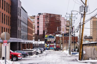 Manchester, New Hampshire, ABD - Karlı caddeye park eden binalar ve arabalarla sokak manzarası