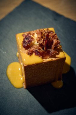 Klasik İtalyan carbonara 'sında yaratıcı bir dönüm noktası, bu makarna küpü yumurta, Pecorino Romano, gevrek guanciale ve karabiberden yapılmış zengin, kremalı bir sosla mükemmel pişirilmiş makarna içerir. Geleneksel bir gurme sunumu 