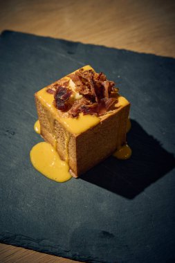 Klasik İtalyan carbonara 'sında yaratıcı bir dönüm noktası, bu makarna küpü yumurta, Pecorino Romano, gevrek guanciale ve karabiberden yapılmış zengin, kremalı bir sosla mükemmel pişirilmiş makarna içerir. Geleneksel bir gurme sunumu 