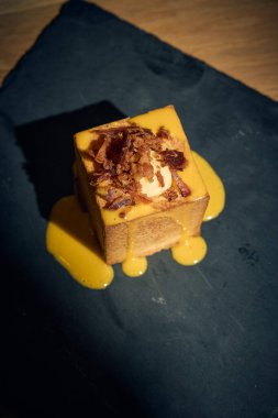 Klasik İtalyan carbonara 'sında yaratıcı bir dönüm noktası, bu makarna küpü yumurta, Pecorino Romano, gevrek guanciale ve karabiberden yapılmış zengin, kremalı bir sosla mükemmel pişirilmiş makarna içerir. Geleneksel bir gurme sunumu 