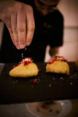İnce dilimlenmiş taze domates ve kokulu fesleğen yapraklarıyla kaplı çıtır çıtır, altın renginde bir hamur. Bu basit ama lezzetli yemek, çıtır çıtır güveç ile taze Akdeniz lezzetini birleştirir. Aperatif ya da sokak yemeği olarak mükemmeldir..