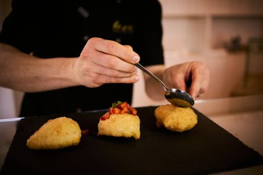 İnce dilimlenmiş taze domates ve kokulu fesleğen yapraklarıyla kaplı çıtır çıtır, altın renginde bir hamur. Bu basit ama lezzetli yemek, çıtır çıtır güveç ile taze Akdeniz lezzetini birleştirir. Aperatif ya da sokak yemeği olarak mükemmeldir..