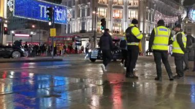 İnsanlar gece sokakta yürürler.