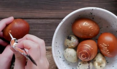 Kadının elleri bıldırcın yumurtasıyla bir tabak tutuyor.