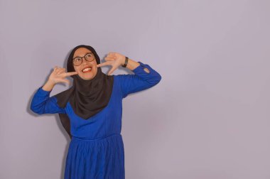 Neşeli kadınların tesettürleri, iki elinde de tezahüratlar ve parmaklar yanaklarını gösteriyor, mutluluğun işareti.