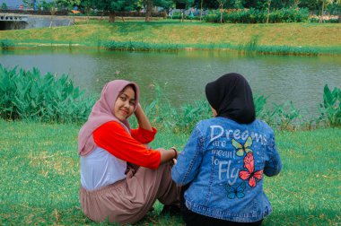 İki arkadaşın yemyeşil bir göl kenarında oturduğu huzurlu bir an..