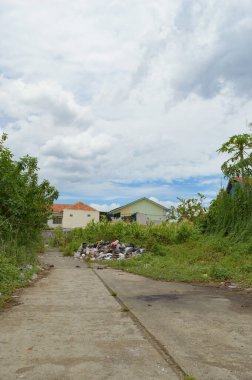 Bir sürü çöpü olan toprak bir yol.