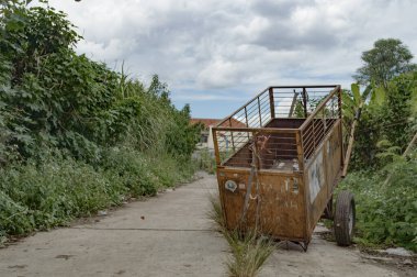 Toprak yola park etmiş bir çöp kamyonu.