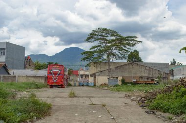 Bir binanın yanına park etmiş kırmızı bir otobüs.