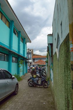 Park etmiş bir sürü motosikleti olan bir cadde.