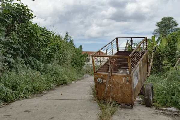 Toprak yola park etmiş bir çöp kamyonu.