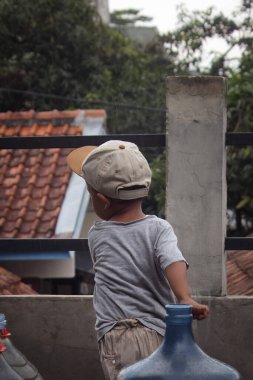 Delikanlı ev bahçesinde oynuyor.