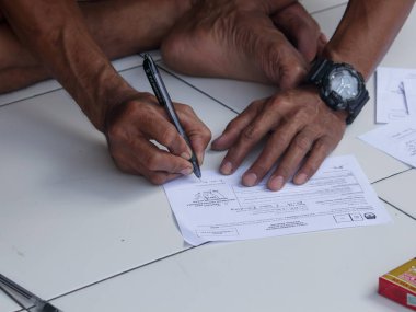 Saat takan bir adam Endonezya 'daki 2024 başkanlık seçimleri için mahkeme celbi yazıyor.