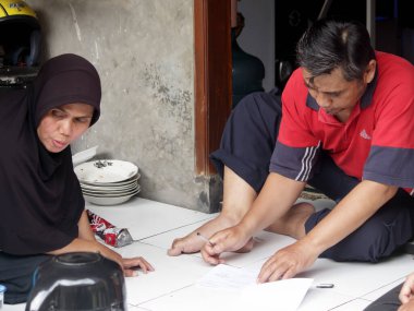 Bandung, Endonezya - 11 Şubat 2024: Endonezya cumhurbaşkanlığı seçimleri için seçim görevlileri halka celp kağıdı dağıttı