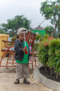 Bandung, Endonezya, 21 Şubat 2024, tatlı Asyalı çocuk Endonezya 'da sabun köpüğü oynuyor.