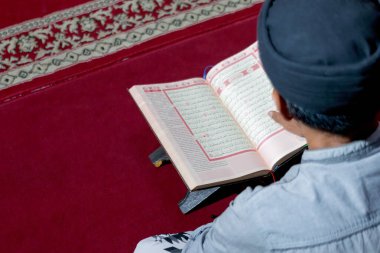 Kur 'an' ı kırmızı halıda okuyan bir adam, Endonezya 'ya derin bir ibadete dalmış, 05 Mart 2025