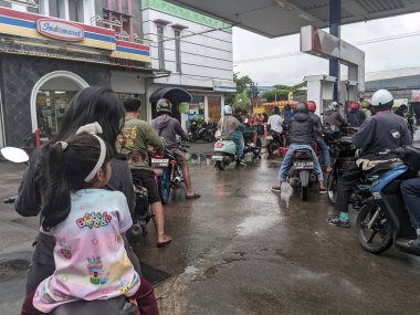 Bulutlu bir günde Bandung Endonezya 'da bir benzin istasyonunda motosikletler uzun bir kuyruk oluşturur, 03 Mart 2025
