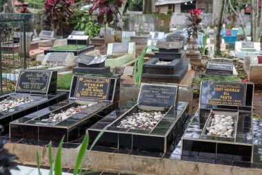 Yeşil ve doğal elementlerle çevrili, Arapça yazıtlı mezar taşlarının bulunduğu huzurlu bir Müslüman mezarlığı, Bandung Endonezya, 06 Mart 2025