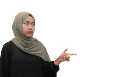 Başörtüsü takmış Müslüman bir kadın yan tarafa bakıyor.