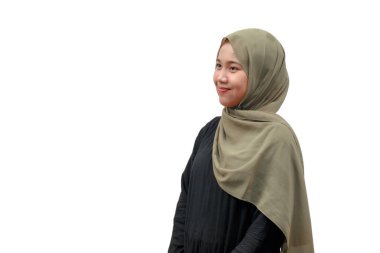 Başörtüsü içinde güzel bir Müslüman kadın gülümsüyor ve yan bakıyor.