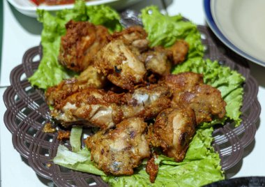 Taze marul yapraklarıyla servis edilen leziz kızarmış tavuk, mutfak sunumları, yemek blogları ve menü sergileri için mükemmel.