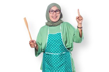 Elinde ahşap bir spatulayla gülümseyen Müslüman kadın ev yemeklerini, aşçılık tutkularını ve mutlu bir yaşam tarzını temsil ediyor.