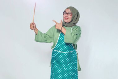 Ahşap bir spatulayla lezzetli yemekler hazırlamaya hazır kendinden emin bir kadın şef.