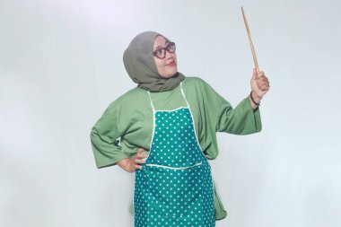 Neşeli kadın şef ahşap mutfak aletini tutuyor, yemek pişirmeye hazır.