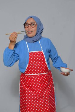 Elinde yemek kabı tutarken yemek yerken gülümseyen bir kadın. Yemek ve yaşam tarzı kavramları için mükemmel.