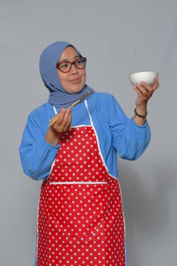 Elinde kâse ve yemek çubuğu tutan gülümseyen kadın, yemek ve yaşam tarzı teması için ideal.