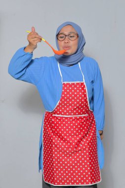 Büyük şef kepçeyle yemek tadıyor, ev yemeği anının tadını çıkarıyor.