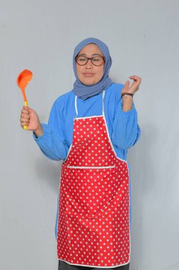 Kıdemli kadın tutku ve ifadeyle yemek pişiriyor, süreçten zevk alıyor.