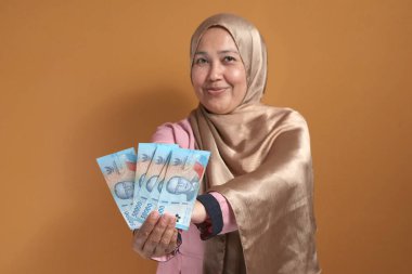 Endonezya Rupiah 'ı elinde tutan kendine güvenen kadın, finansal başarı ve güç gösteriyor.