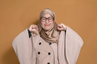 Kendine güveni tam Müslüman bir kadın neşeli bir yüz ifadesiyle pozitifliğini ifade ediyor.