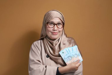 Gülümseyen Müslüman Kadın Endonezya Rupia Parasını Tutuyor
