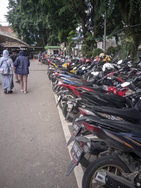 Bandung, Endonezya - Mart 04, 2025: Ujungberung Hastanesi 'ndeki kalabalık motosiklet parkı, kasklı bir dizi motosikleti gösteriyor