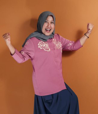 Stüdyoda zafer jesti ile poz veren Müslüman kadın, gururlu bir şekilde çeşitliliği güçlendirme ve motivasyon temaları arıyor