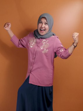 Neşeli bir portrede neşe ve güç ifade eden kendinden emin Müslüman kadın, çeşitlilik, güç ve kültürel temsil içeriği için ideal.