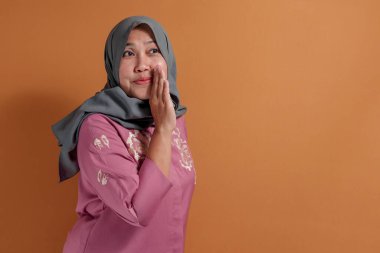 Şaşırmış müslüman kadın, tuhaf bir yüz ve yanakla tepki veriyor.