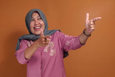 Kendine güveni tam bir müslüman kadın, parmaklarıyla işaret ediyor.