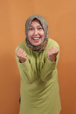 Neşeli Müslüman kadın gururlu ve kendinden emin pozuyla başarısını ifade ediyor.