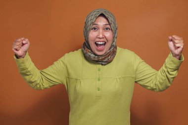 Heyecanlı Müslüman kadın sevinçle, motivasyonla, yumrukla yükseldi