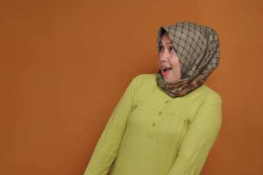 Şaşırmış Müslüman kadın heyecanla ve neşeli bir ifadeyle tepki veriyor.