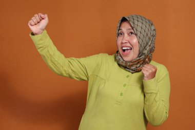 Neşeli Müslüman kadın başarıyı heyecan ve enerjiyle kutluyor.