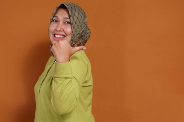 Müslüman kadın, iletişim, tanıtım ve yaşam tarzı konsepti için gülümseyerek beni çağırıyor.