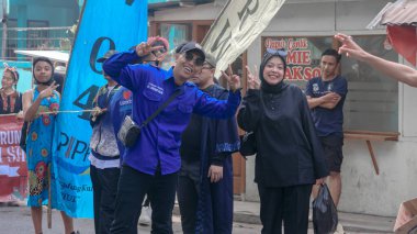 Canlı bir topluluk etkinliği sırasında dışarıda poz veren, kültürel kıyafetler ve pozitif enerji sergileyen neşeli bir grup insan Bandung - Endonezya, 17 Ağustos 2024